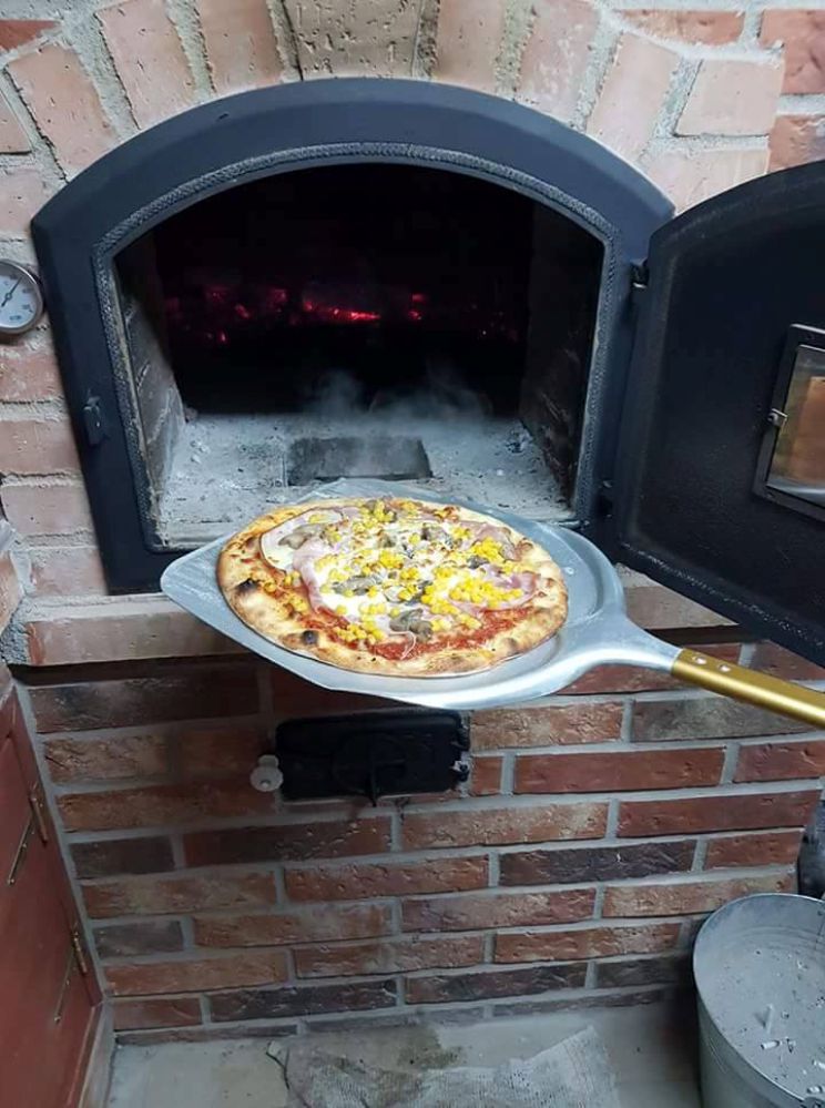 Pizza pečená v drevnej peci Pecmaniak priamo pred rozohriatym ohniskom